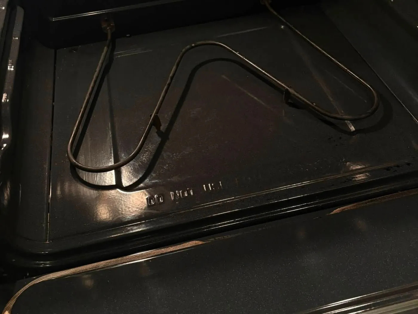 The same oven after cleaning: the floor and element wiped back to bare black.